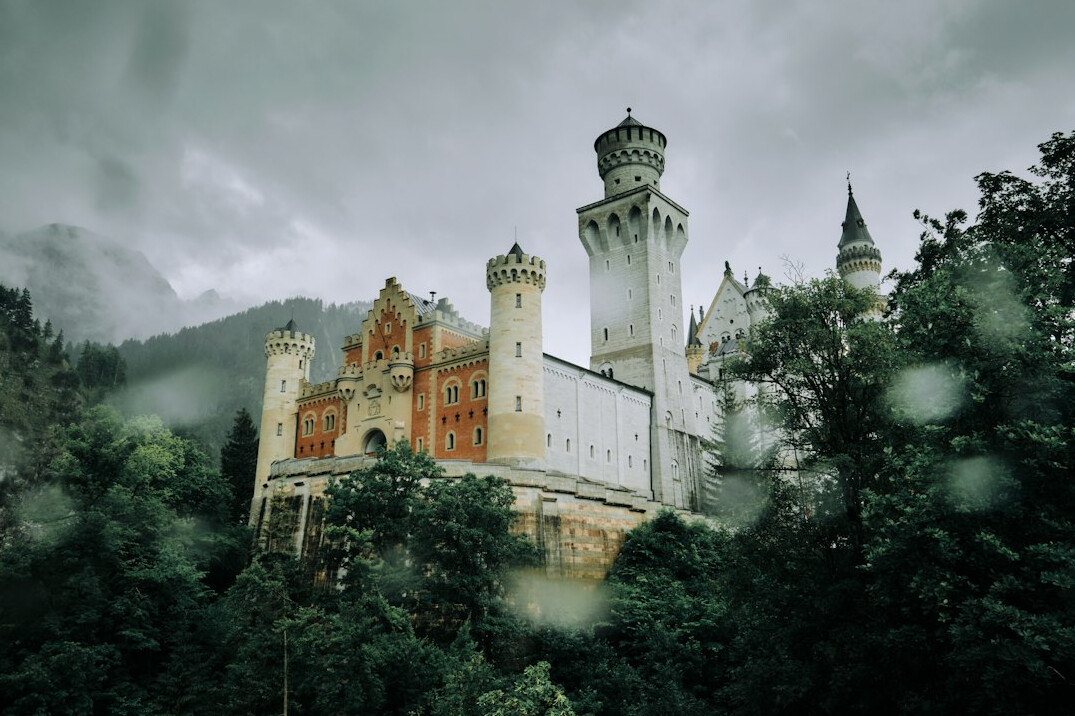 Neuschwanstein Castle surrounded by Bavarian forest and mountains